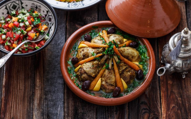 Tajine de poulet aux abricots marocain traditionnel avec amandes et épices orientales, plat sucré-salé parfumé au four ou mijoté