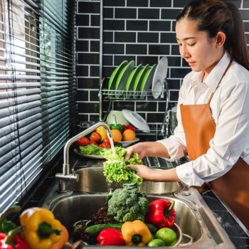 Hand of maid washing tomato fresh vegetables preparation healthy food in kitchen